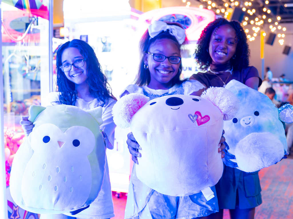 three young girls holding up prizes