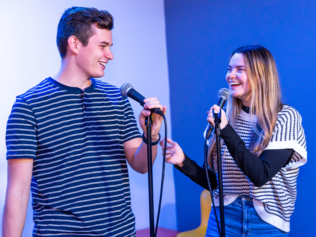 two young adults singing together