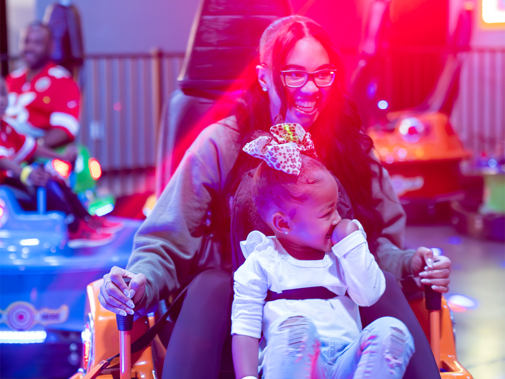 two sisters smiling and enjoying bumper cars